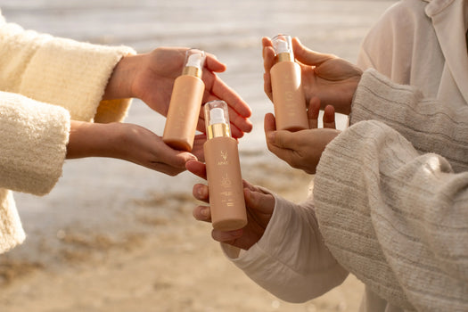 Hands holding natural Irish skincare serums on a beach, pH-balanced for sensitive skin