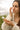 Woman applying natural skincare serum outdoors, gentle face care for sensitive skin