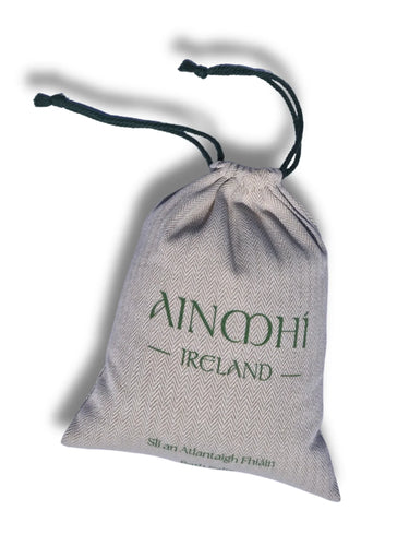Grey herringbone fabric drawstring pouch with AINMHÍ IRELAND branding.