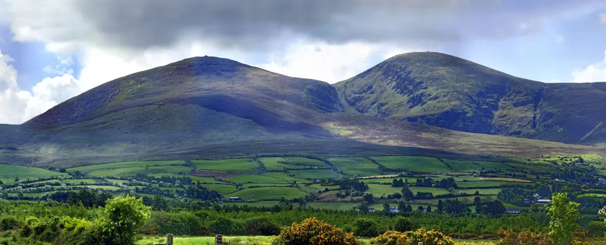 Lush green Irish hills and rolling countryside under dramatic sky, natural skincare inspiration